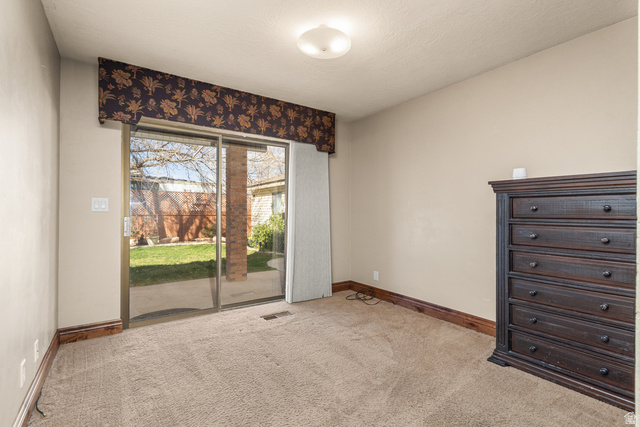 892 Cambridge Drive St. George, UT 84770 - Photo 19 of 65 Room featuring neutral wall paint, textured carpet flooring, and dark wood-finish baseboards