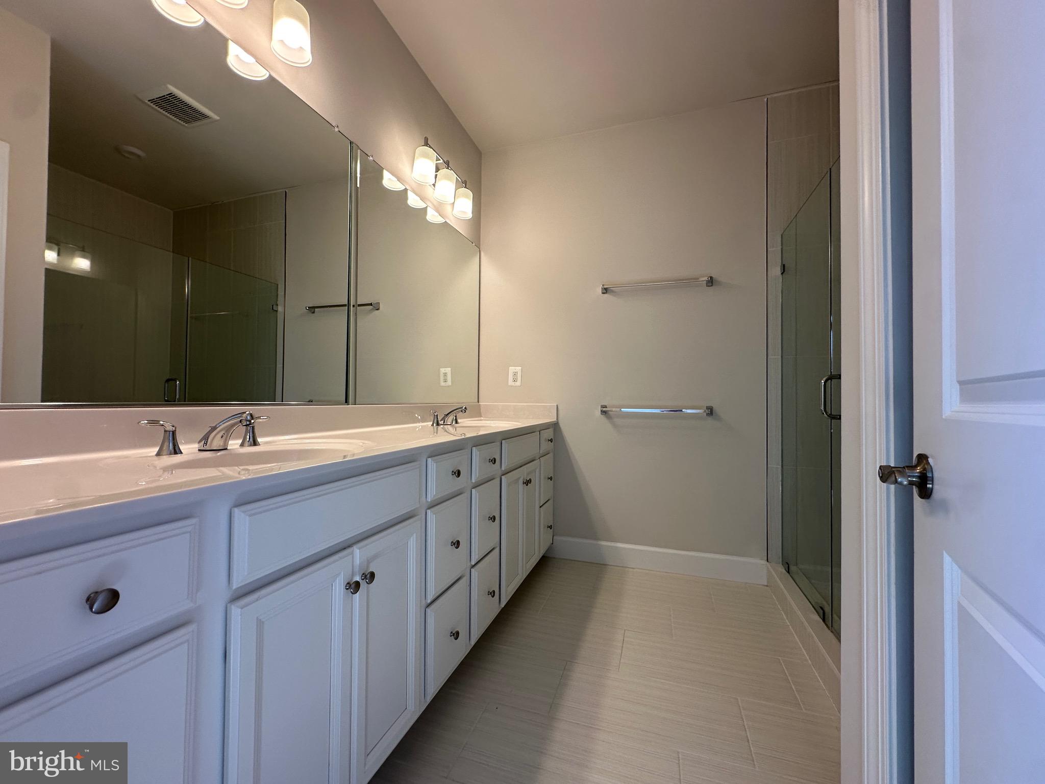 9886 Hopkins Loop Manassas, VA 20110 - Photo 35 of 50 a bathroom with a double vanity sink and mirror