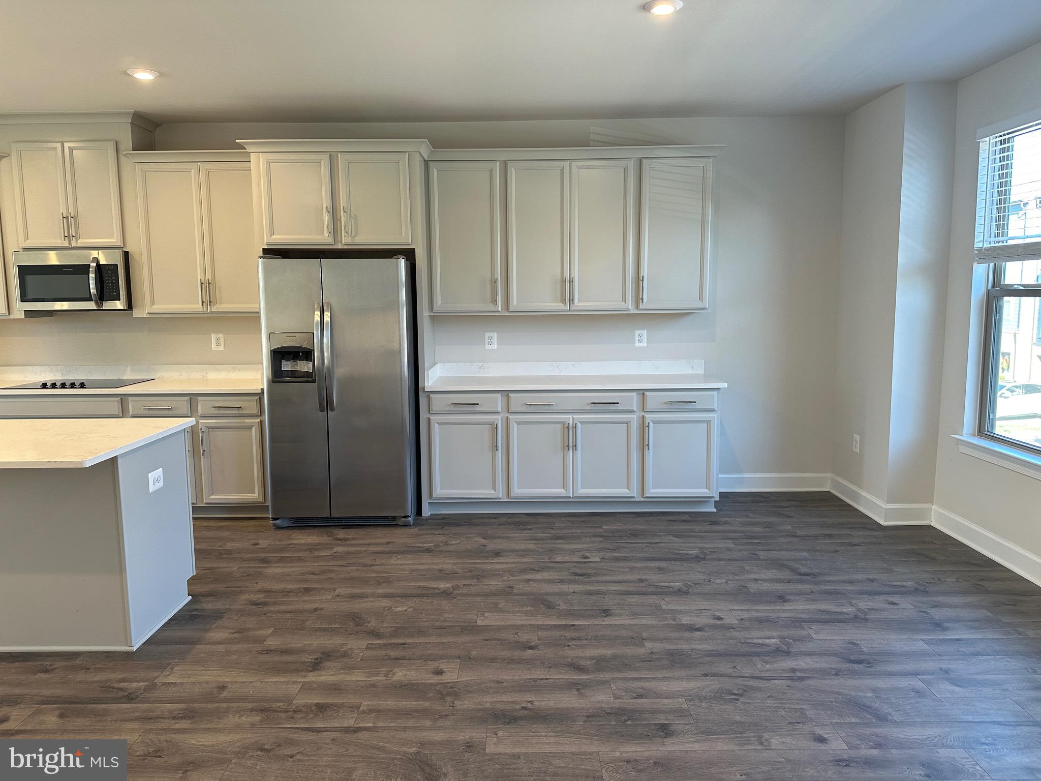 9886 Hopkins Loop Manassas, VA 20110 - Photo 6 of 50 a kitchen with kitchen island granite countertop a stove a sink and a refrigerator