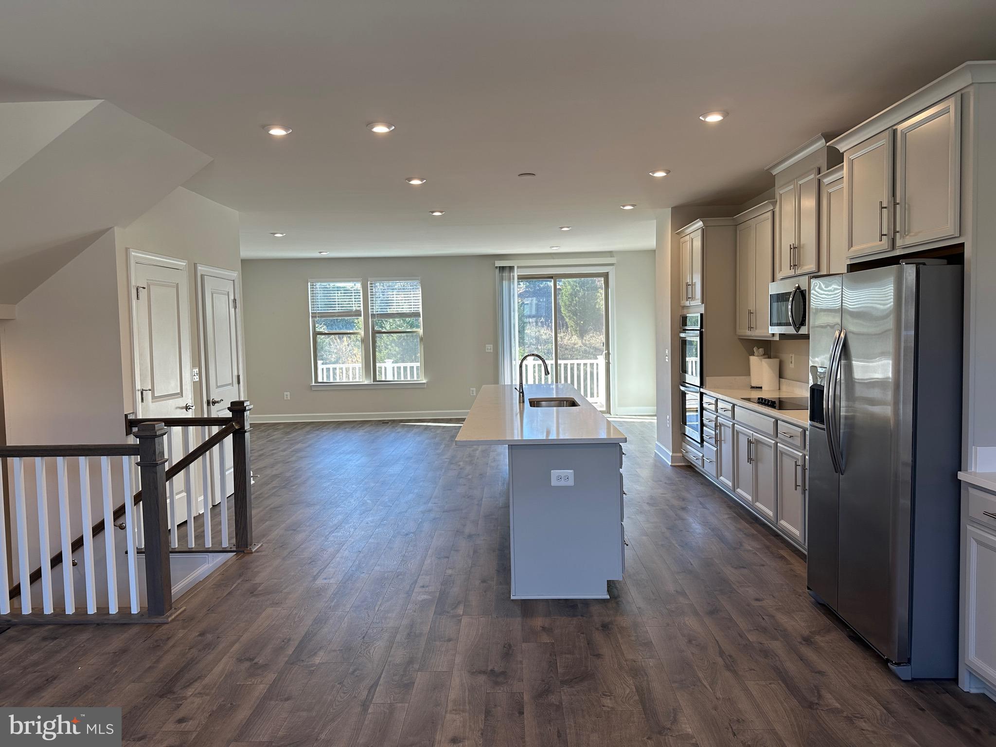 9886 Hopkins Loop Manassas, VA 20110 - Photo 10 of 50 a open kitchen with kitchen island wooden floors wooden cabinets and stainless steel appliances