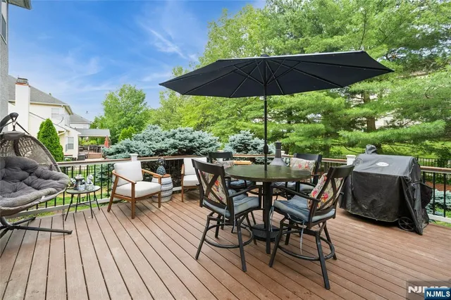 a view of a roof deck with table and chairs under an umbrella