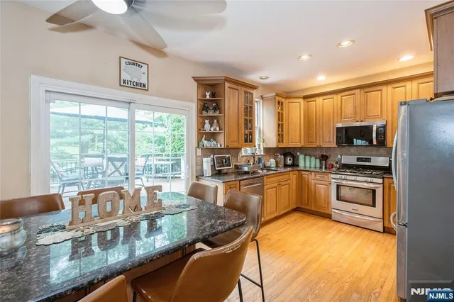 a kitchen with kitchen island granite countertop a stove top oven microwave and refrigerator