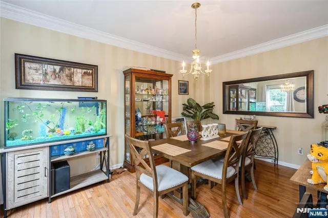 a view of a dining room with furniture a chandelier and wooden floor