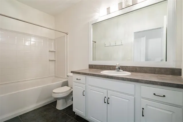 a bathroom with a granite countertop toilet a sink and a bathtub