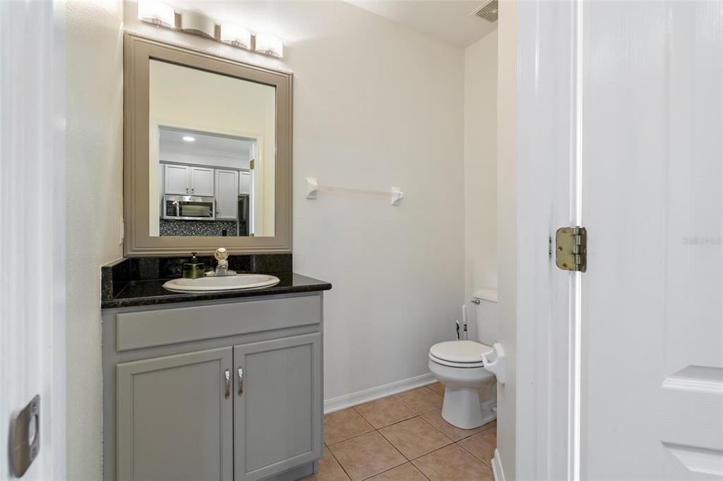 15929 Fishhawk Creek Lane Lithia, FL 33547 - Photo 16 of 25 a bathroom with a granite countertop sink a toilet and a mirror