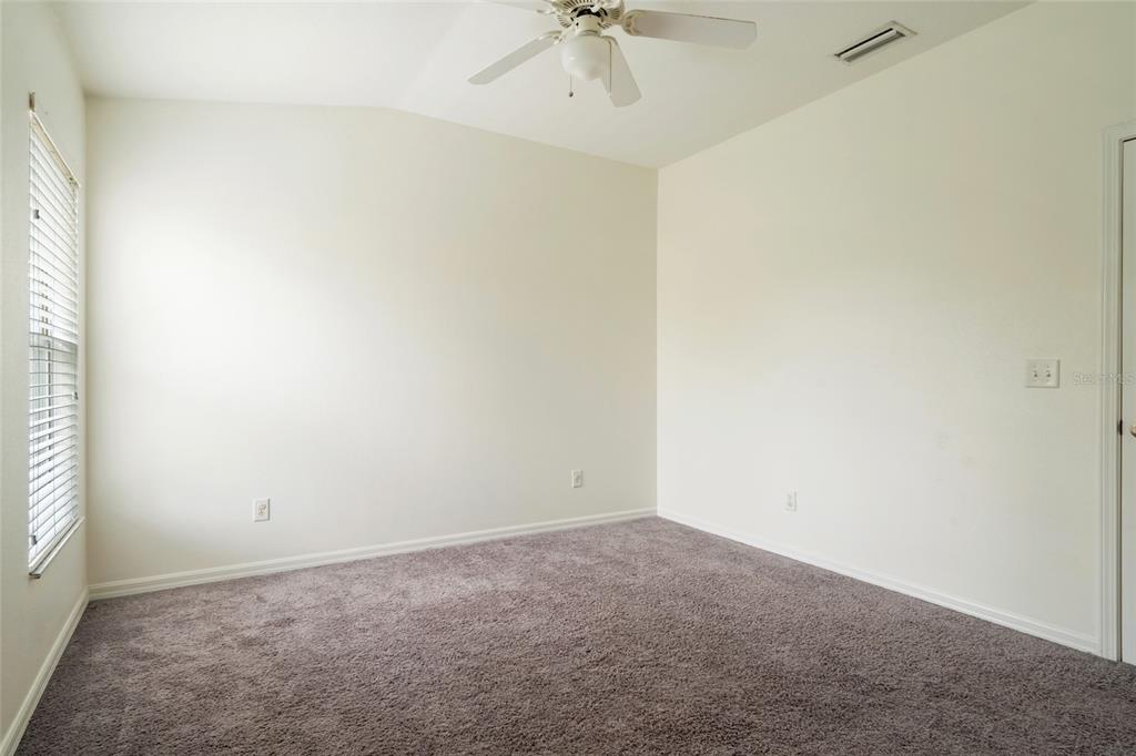 15929 Fishhawk Creek Lane Lithia, FL 33547 - Photo 19 of 25 an empty room with a ceiling fan and a window