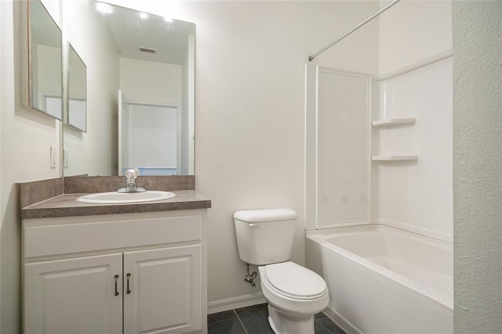 15929 Fishhawk Creek Lane Lithia, FL 33547 - Photo 22 of 25 a bathroom with a granite countertop toilet a sink and a bathtub