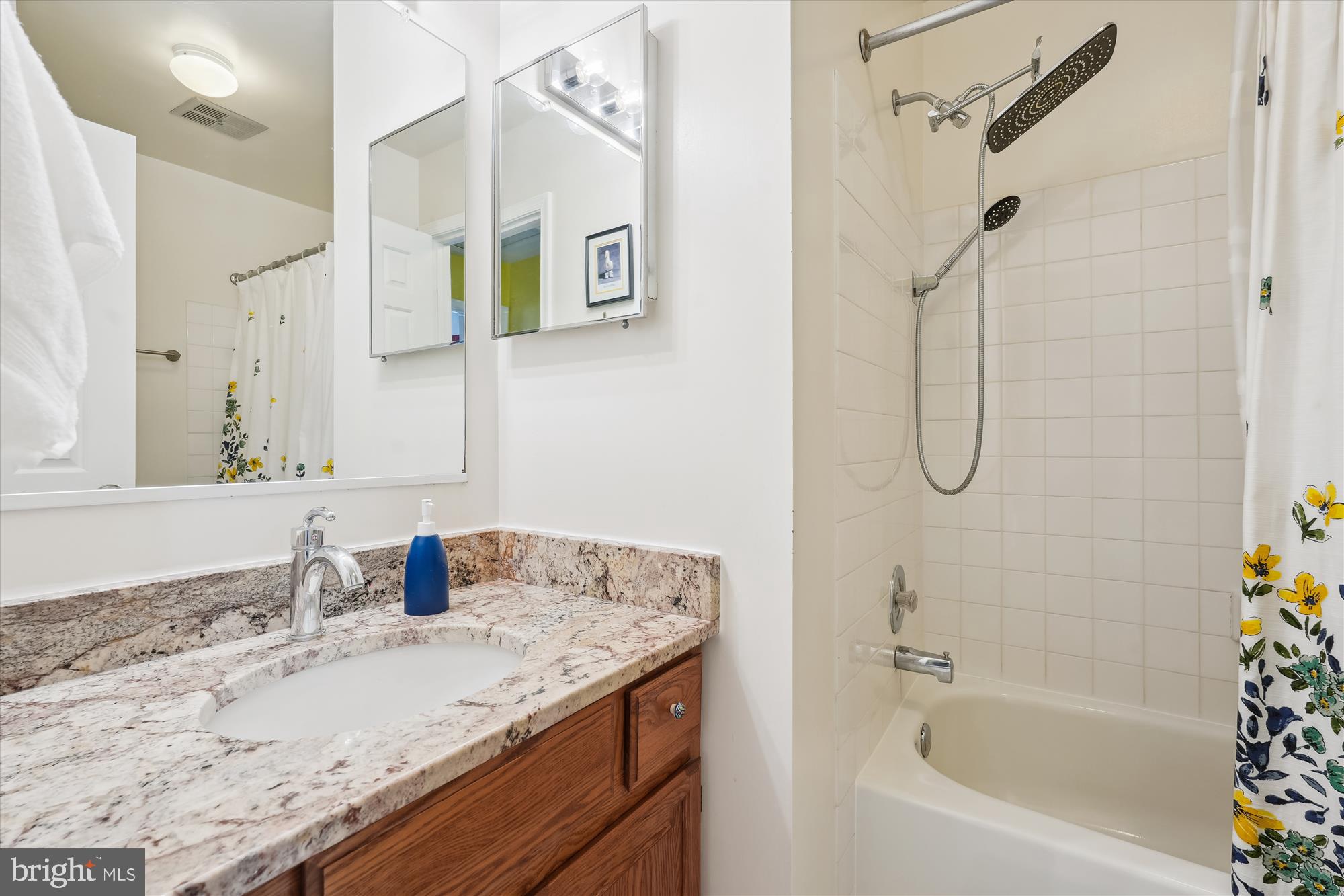 2917 Gracefield Road Silver Spring, MD 20904 - Photo 31 of 51 a bathroom with a granite countertop sink a mirror a vanity and bathtub