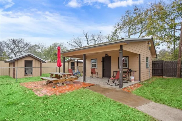 a view of a house with backyard and sitting area