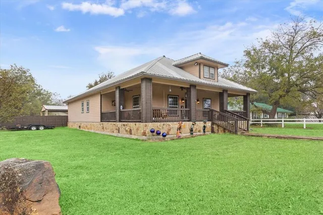 a view of a house with a yard and sitting area