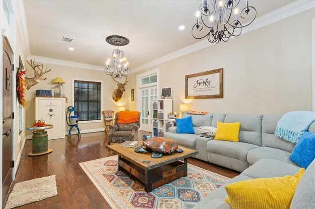 a living room with furniture a chandelier and a rug