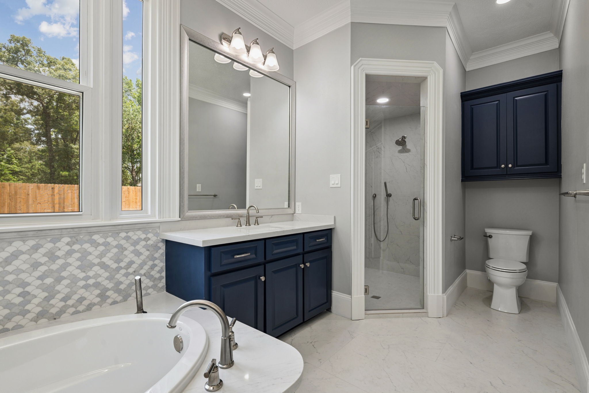 18489 Country Pl Drive Conroe, TX 77302 - Photo 22 of 50 a bathroom with a tub sink toilet and mirror