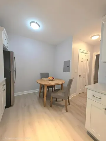 a view of a dining room with furniture and a refrigerator