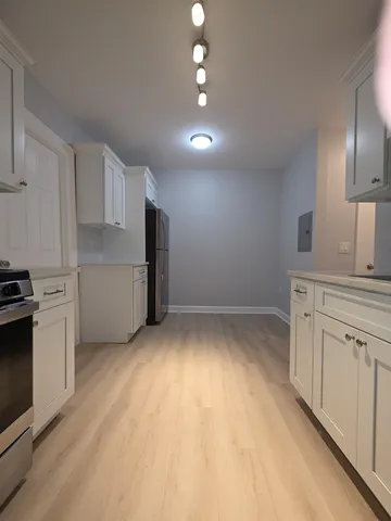 a kitchen with cabinets and wooden floor