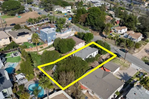 an aerial view of a tennis ground and a cars park side of the road