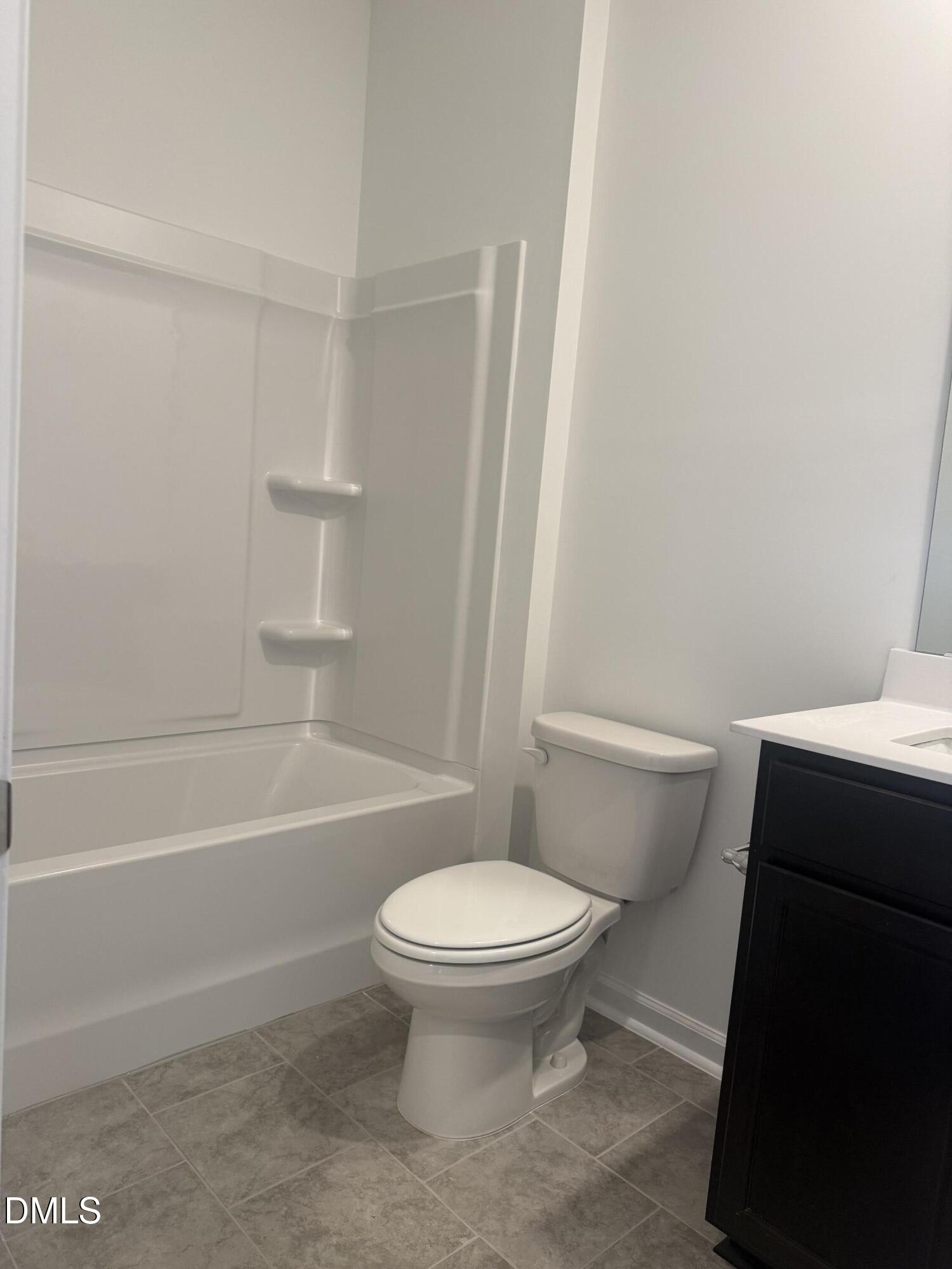 1028 Red Finch Way Angier, NC 27501 - Photo 15 of 50 a bathroom with a toilet and a bath tub