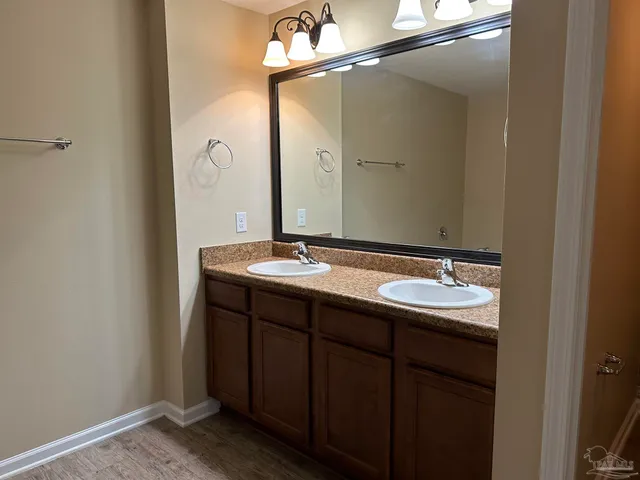a bathroom with a granite countertop toilet sink and mirror