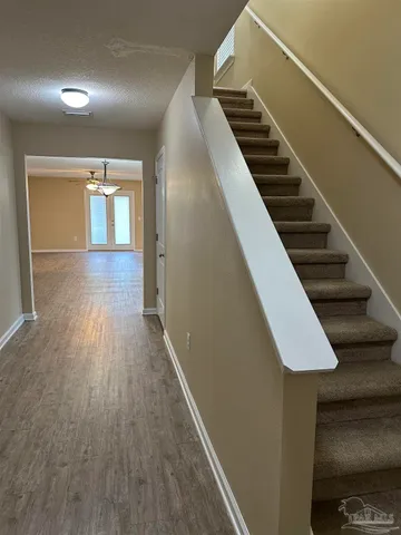 a view of a hallway with wooden floor and staircase