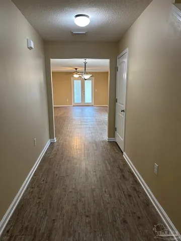 a view of a room with a chandelier and wooden floor