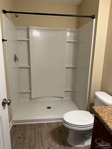 a bathroom with a granite countertop sink toilet and shower