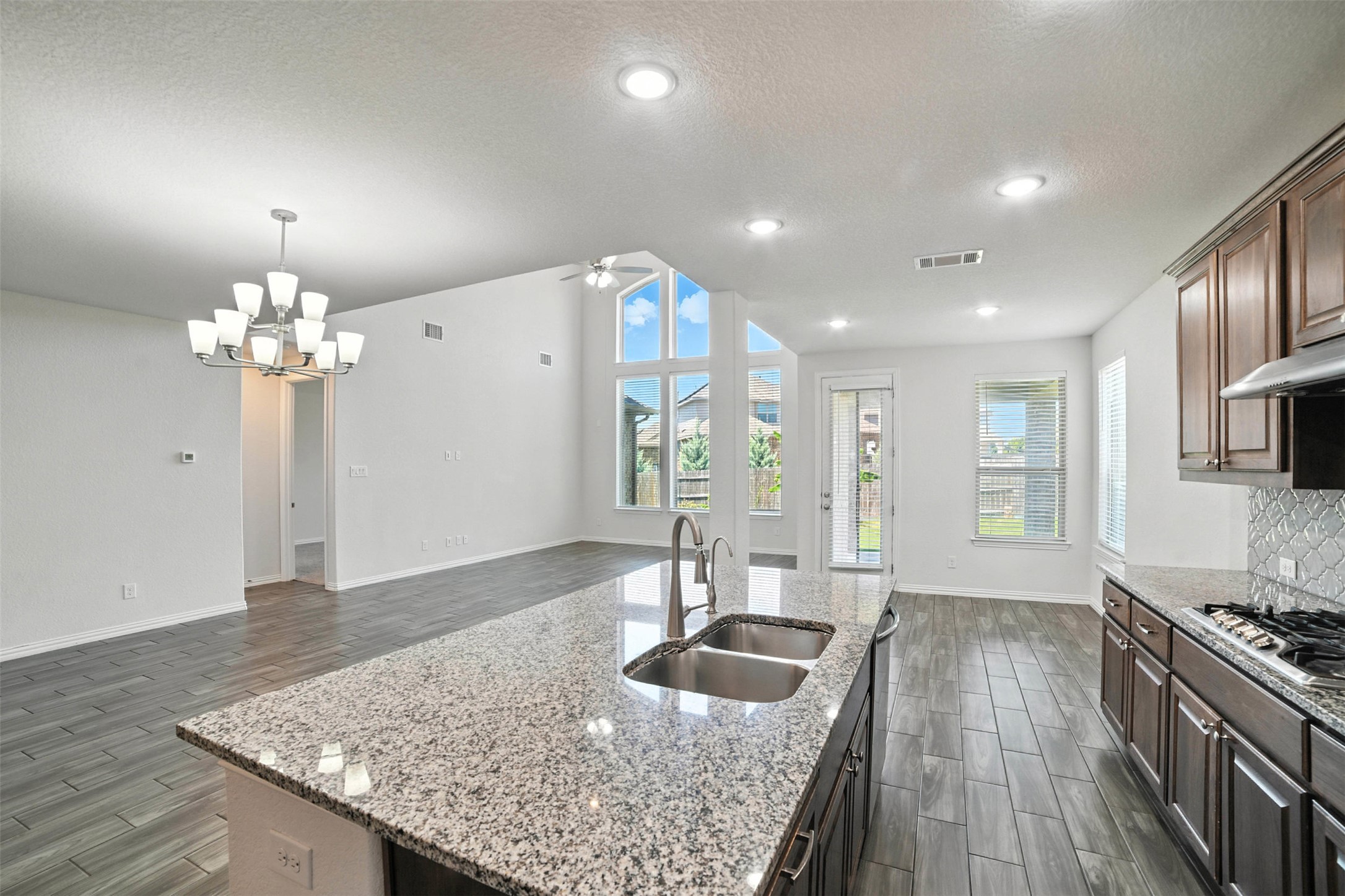 3054 Columbus Loop Round Rock, TX 78665 - Photo 40 of 40 Kitchen with open floor plan, a textured ceiling, ceiling fan, plenty of natural light, and wood finish floors