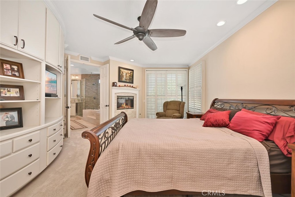 6546 Morningside Drive Huntington Beach, CA 92648 - Photo 47 of 74 a spacious bedroom with a bed a dresser and a chandelier