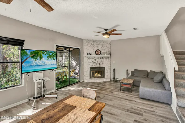 a living room with furniture a fireplace and a flat screen tv