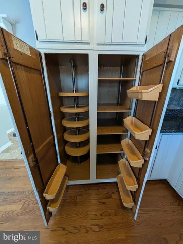 a view of an empty room with wooden floor and stairs