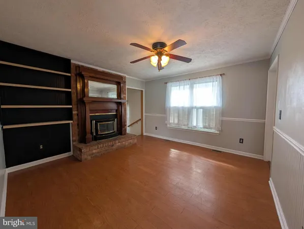 a view of an empty room with a window and a kitchen