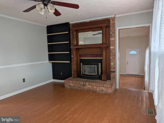 a living room with a fireplace and a ceiling fan