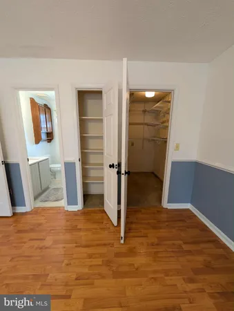 a view of a bedroom with wooden floor and closet