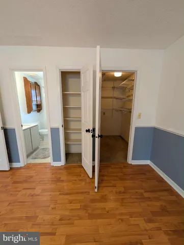 a view of a bedroom with wooden floor and closet