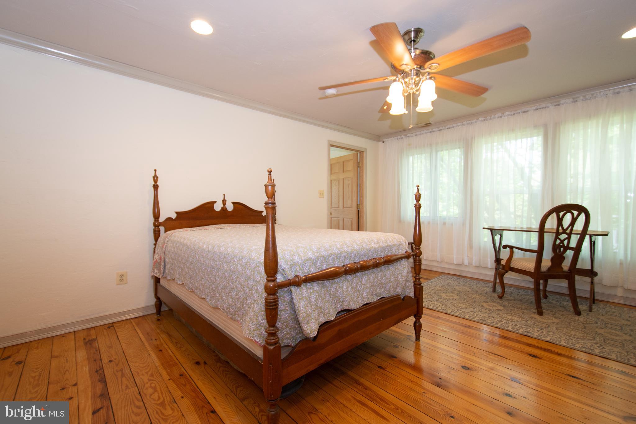 608 Charles Avenue Deale, MD 20751 - Photo 35 of 41 a bedroom with a bed a dresser and wooden floor