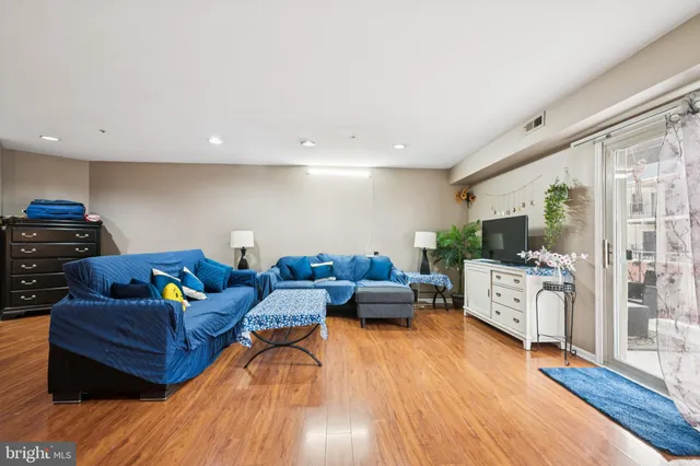 a living room with furniture and a wooden floor
