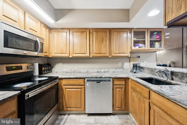 a kitchen with stainless steel appliances granite countertop a sink stove and microwave