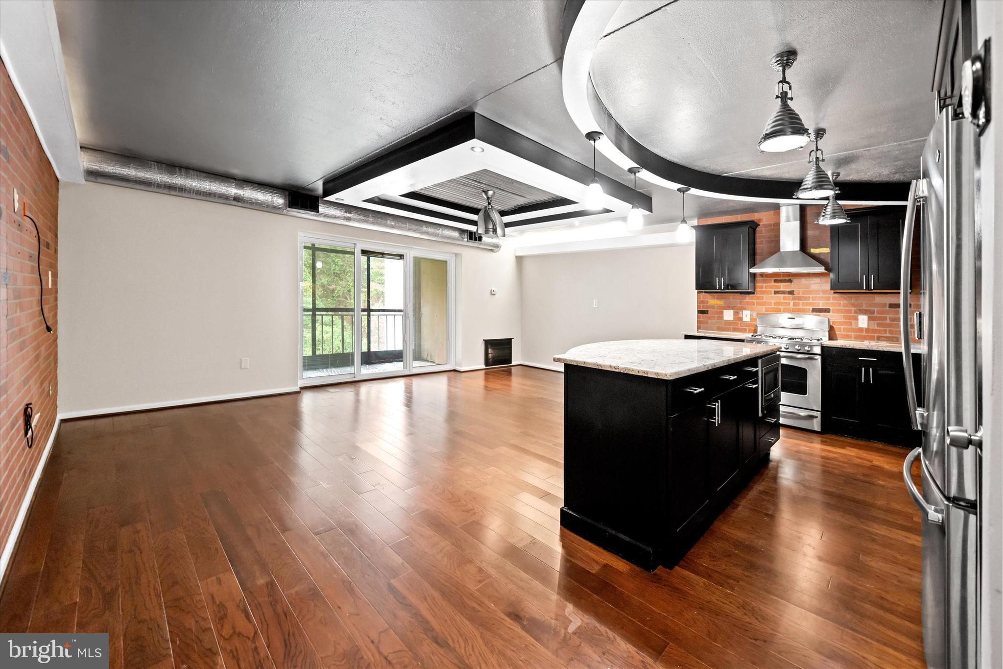 80 Welsh Tract Road, Unit G209 Newark, DE 19713 - Photo 11 of 26 a large kitchen with stainless steel appliances granite countertop a stove and a wooden floors