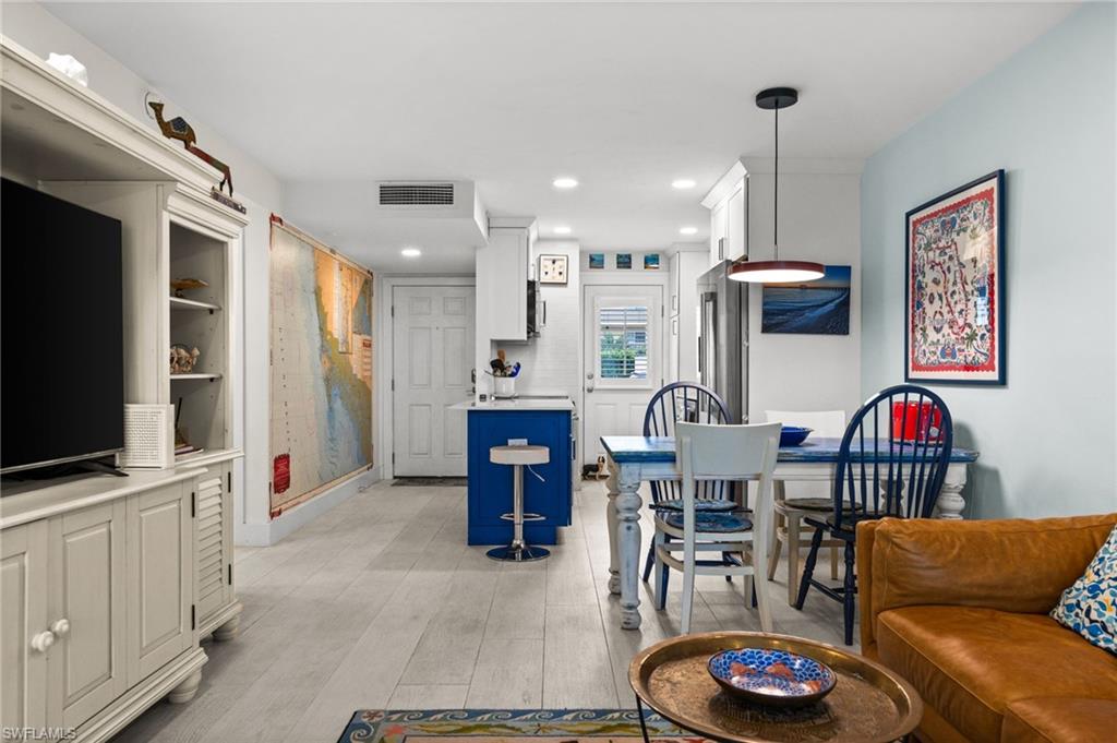 1021 3rd Street South, Unit 112 Naples, FL 34102 - Photo 11 of 27 a living room with furniture kitchen view and a flat screen tv