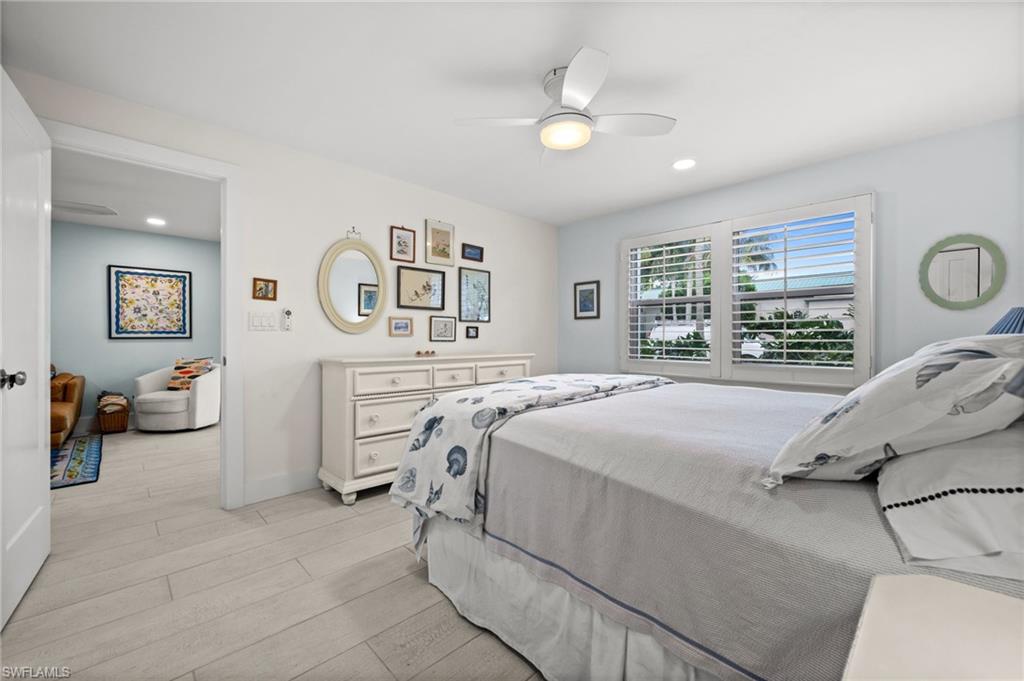 1021 3rd Street South, Unit 112 Naples, FL 34102 - Photo 16 of 27 a bedroom with a bed and a chandelier