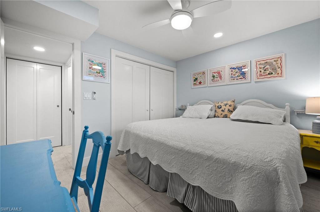 1021 3rd Street South, Unit 112 Naples, FL 34102 - Photo 19 of 27 a bedroom with a bed and a chandelier