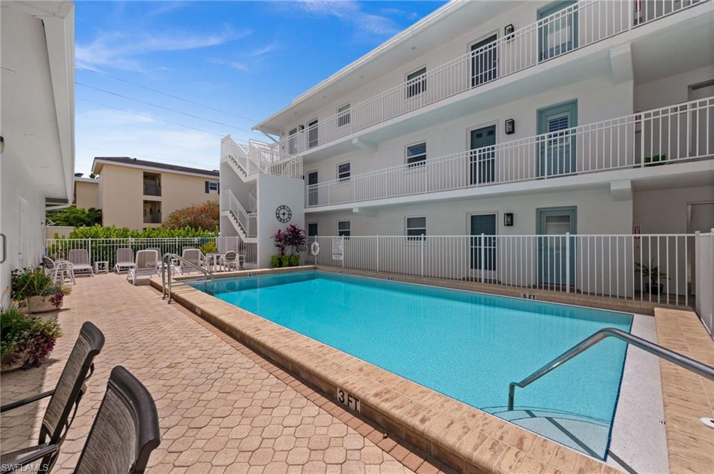1021 3rd Street South, Unit 112 Naples, FL 34102 - Photo 26 of 27 a swimming pool with outdoor seating and yard