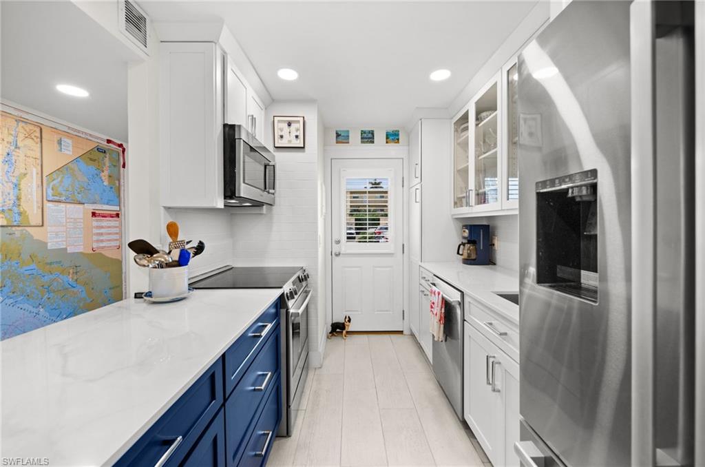 1021 3rd Street South, Unit 112 Naples, FL 34102 - Photo 6 of 27 a kitchen with a sink stove and refrigerator