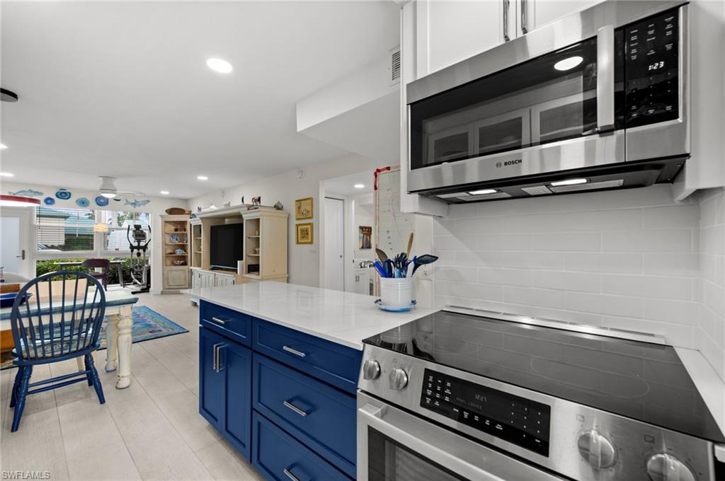 1021 3rd Street South, Unit 112 Naples, FL 34102 - Photo 7 of 27 a kitchen with a stove and a microwave