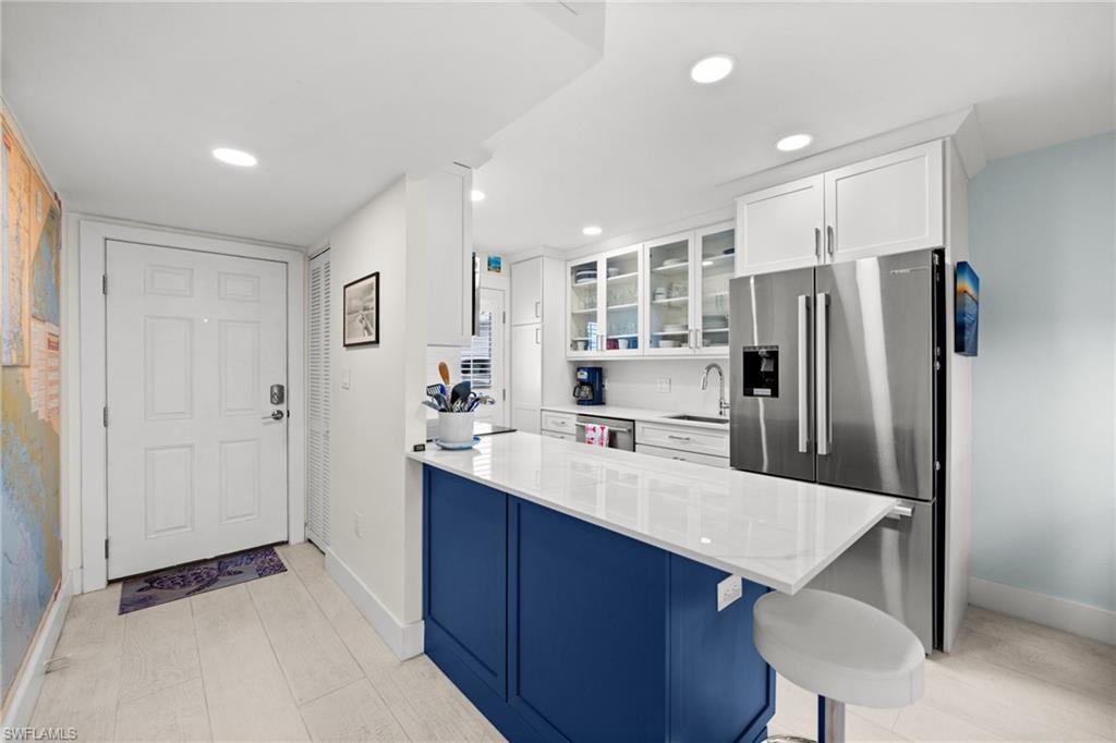 1021 3rd Street South, Unit 112 Naples, FL 34102 - Photo 8 of 27 a kitchen with stainless steel appliances a refrigerator and a sink