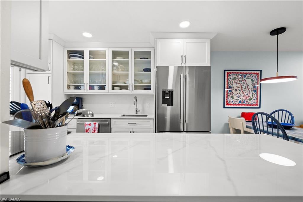 1021 3rd Street South, Unit 112 Naples, FL 34102 - Photo 10 of 27 a kitchen with a refrigerator and a sink