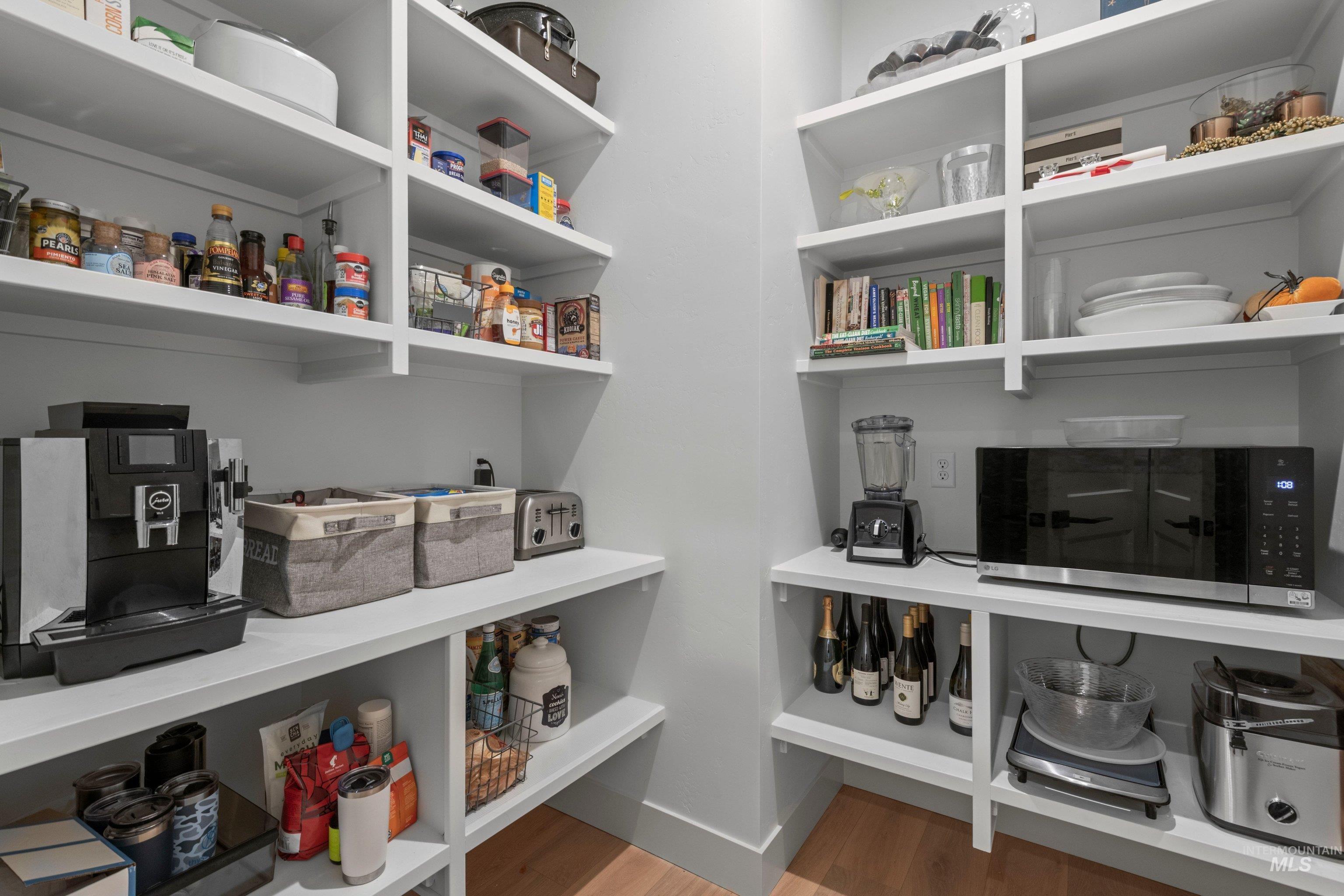 24990 Belgian Way Middleton, ID 83644 - Photo 17 of 50 Integrated pantry featuring extensive white shelving, light wood-finish flooring, and ample storage capacity