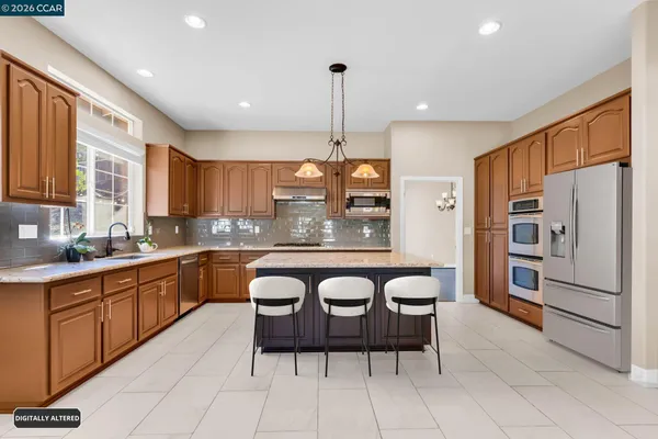 a large kitchen with a refrigerator a sink and cabinets