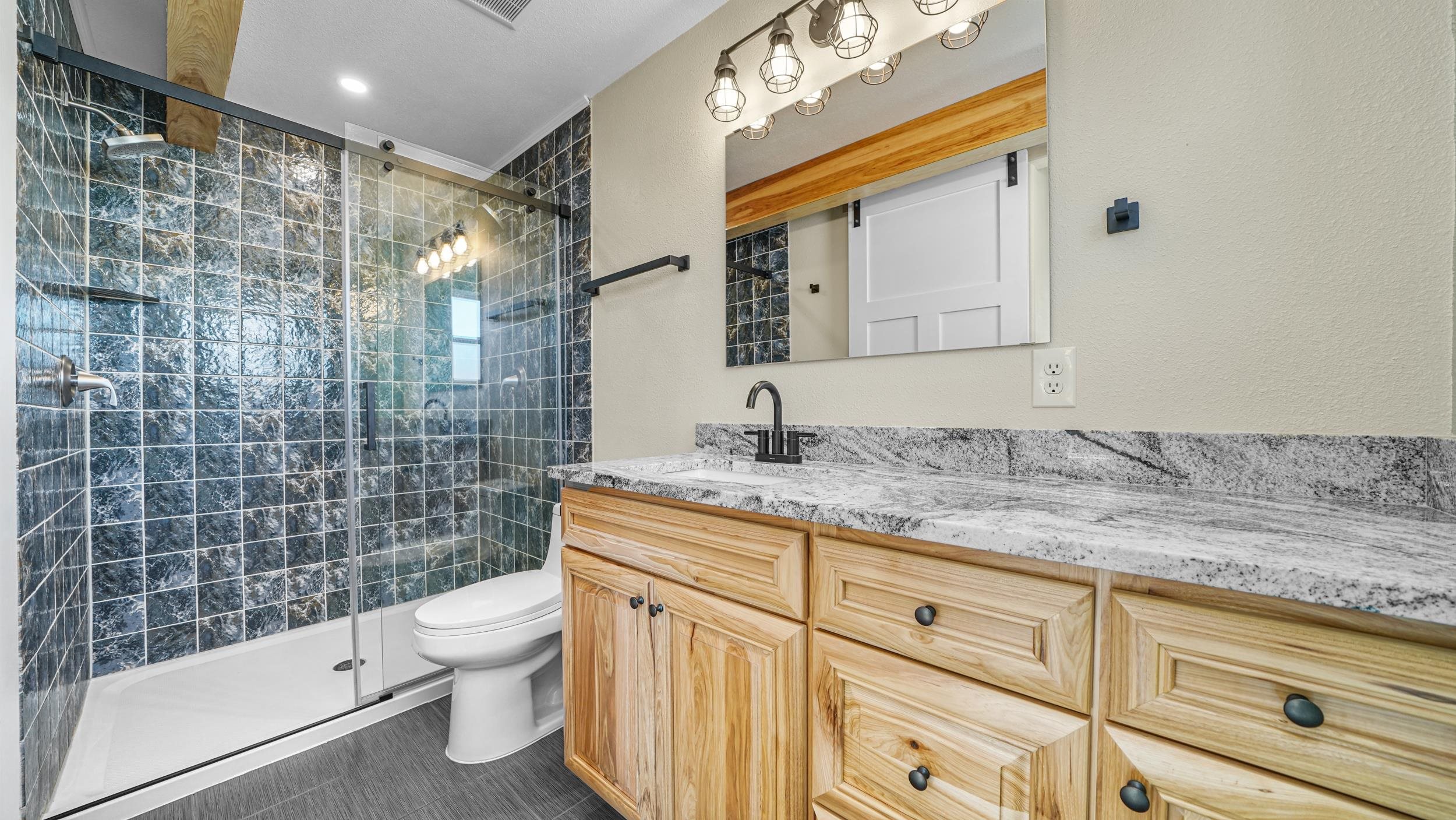 1631 Ptarmigan Ridge Court Grand Junction, CO 81506 - Photo 26 of 33 a bathroom with a granite countertop sink a toilet and shower