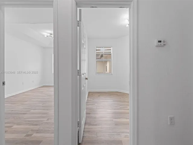 a view of a hallway with wooden floor