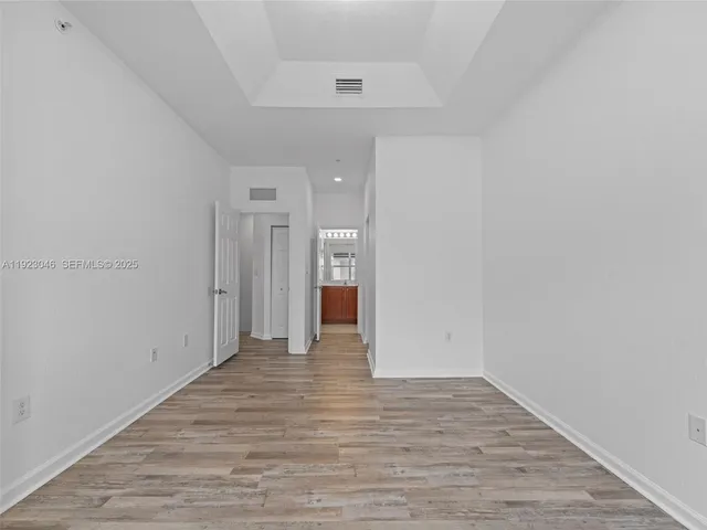 a view of an empty room with wooden floor
