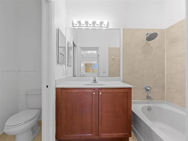 a bathroom with a granite countertop sink a toilet and shower